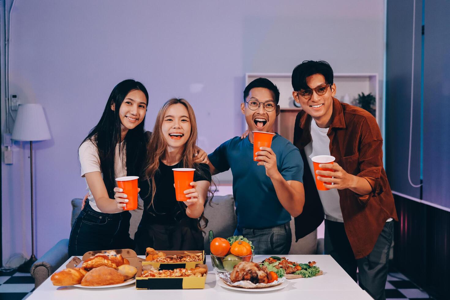 Four friends posing for a photo with food