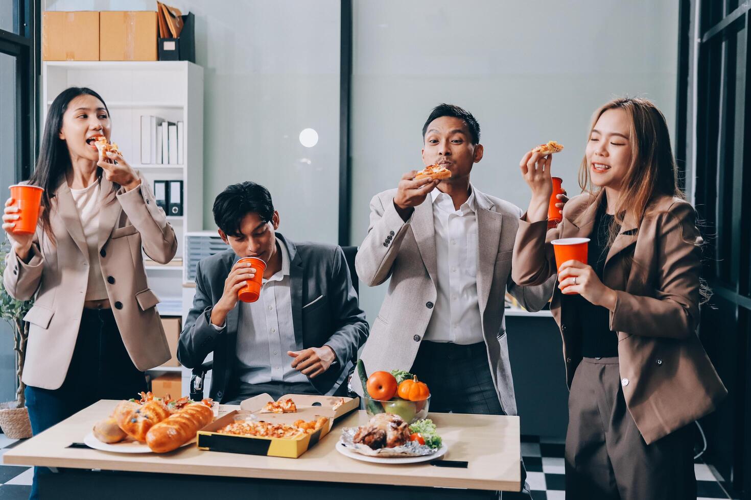 Group of business people eating pizza and drinking soda photo