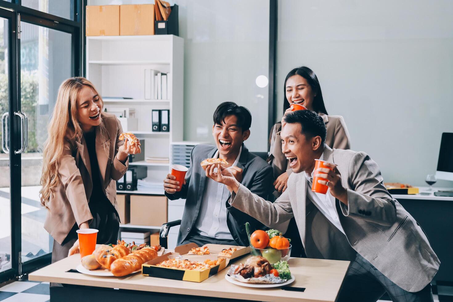 Business people eating food and drinking soda in office photo