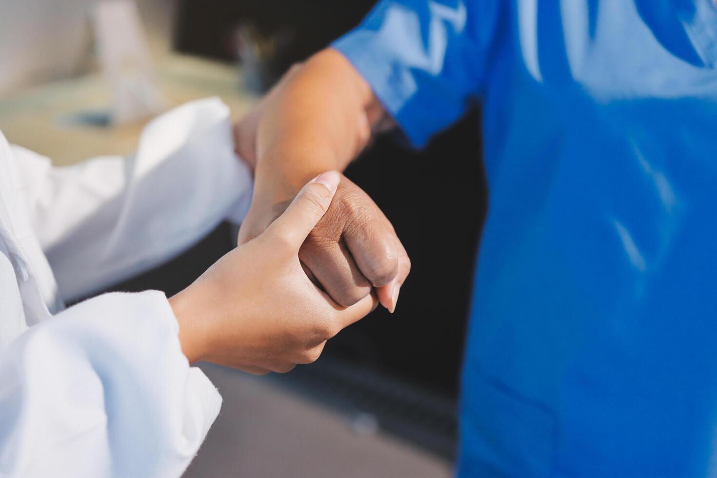 A nurse holding the hand of a patient photo