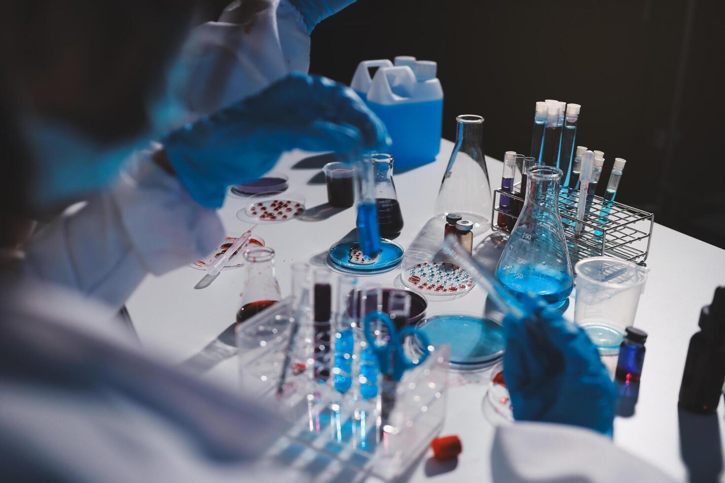 A person in a lab coat is working on a test tube photo