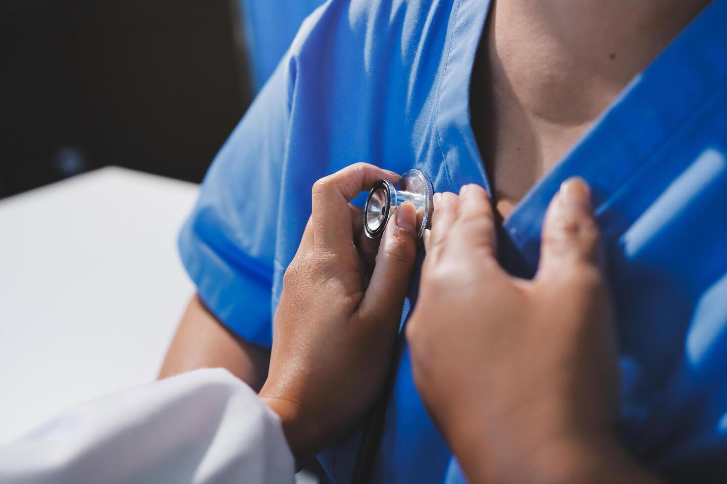 A nurse is putting a stethoscope on a patient's chest photo
