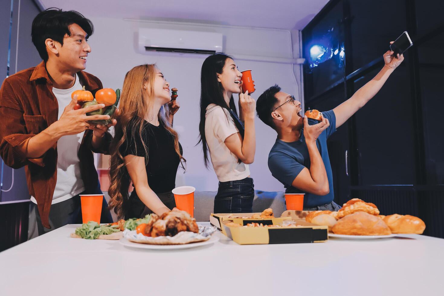 Group of friends enjoying food and drinks at home photo