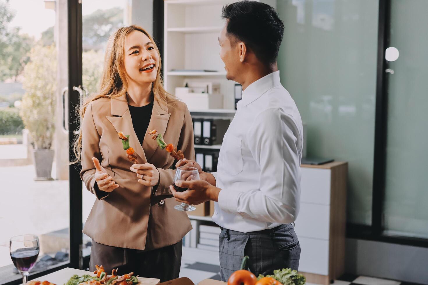 A man and woman are standing in front of a table with food photo