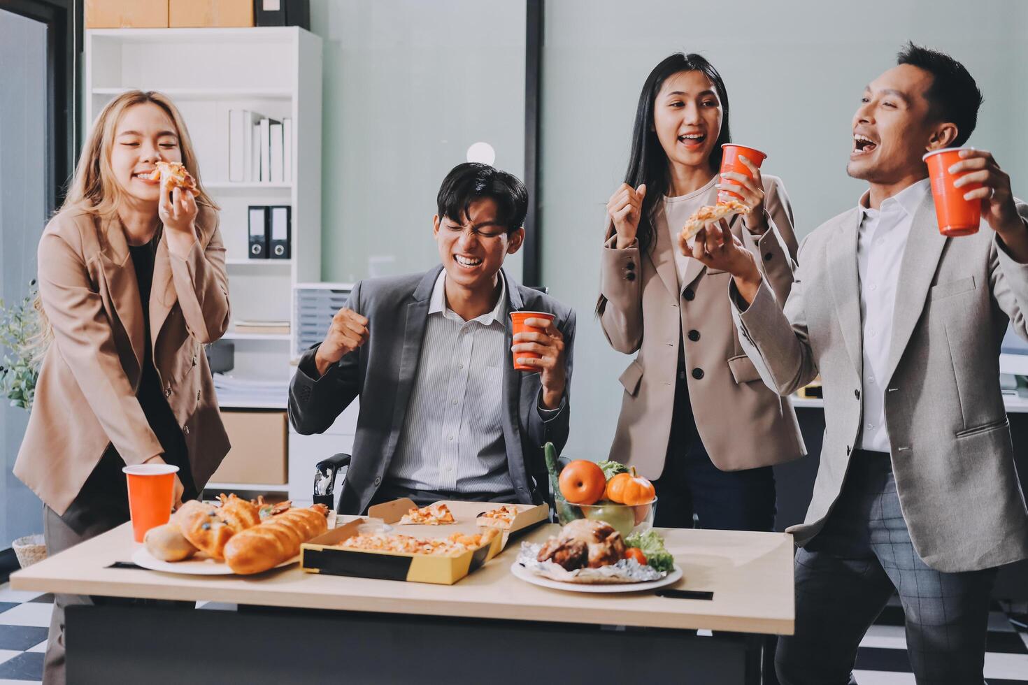 Business people eating pizza and drinking coffee photo