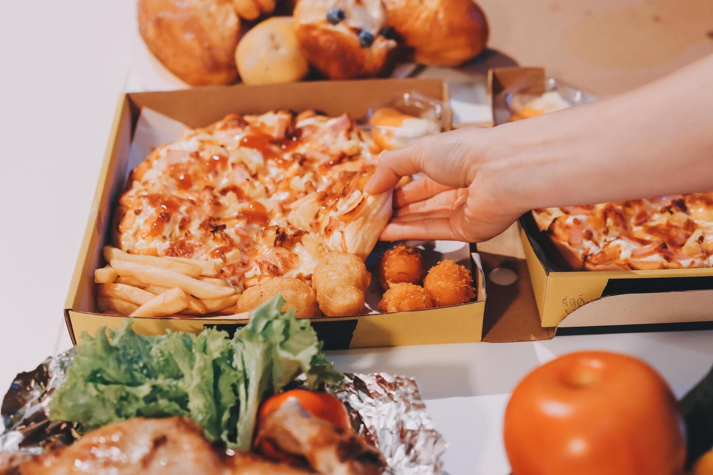A person taking a piece of pizza out of a box photo