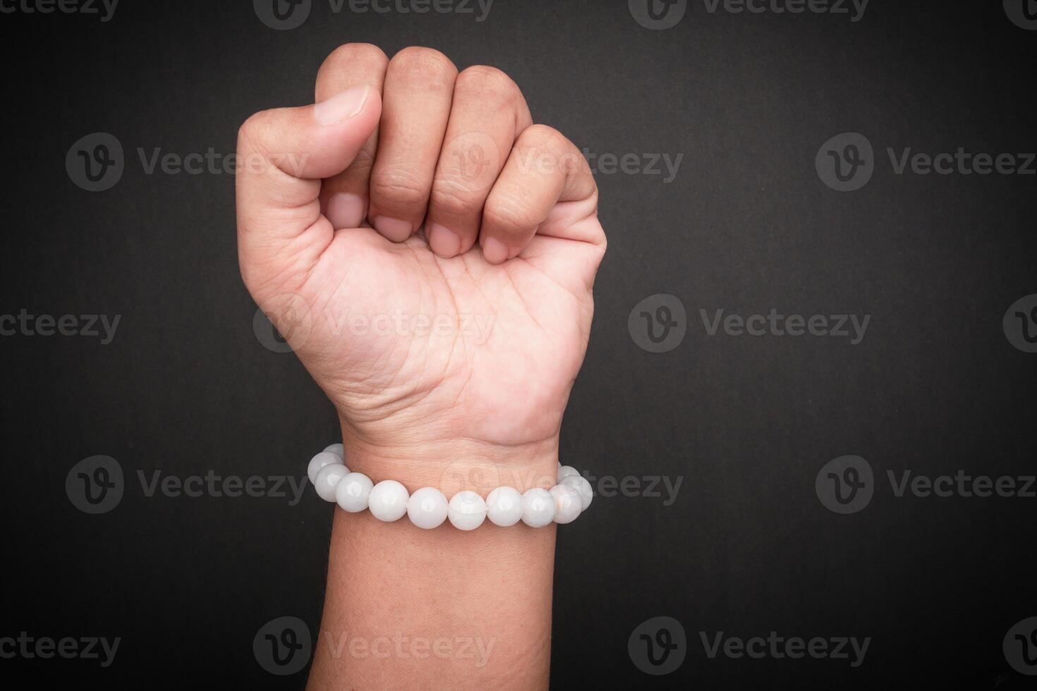 White jade bangles or bracelets in hand against a black background. Close-up. photo