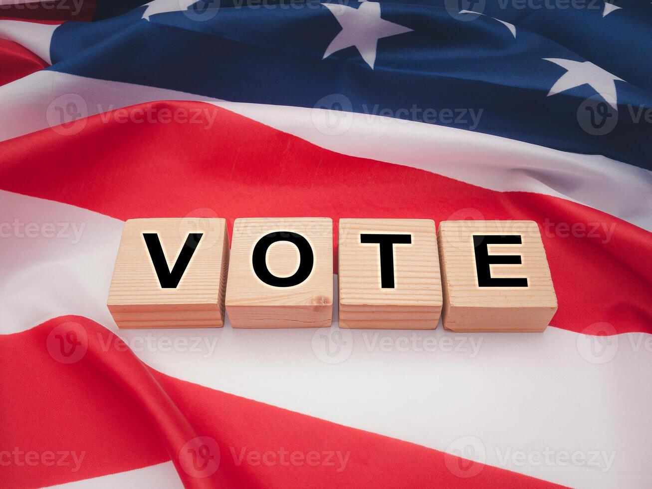 Top view of wooden cubes with letters VOTE over the American flag background photo