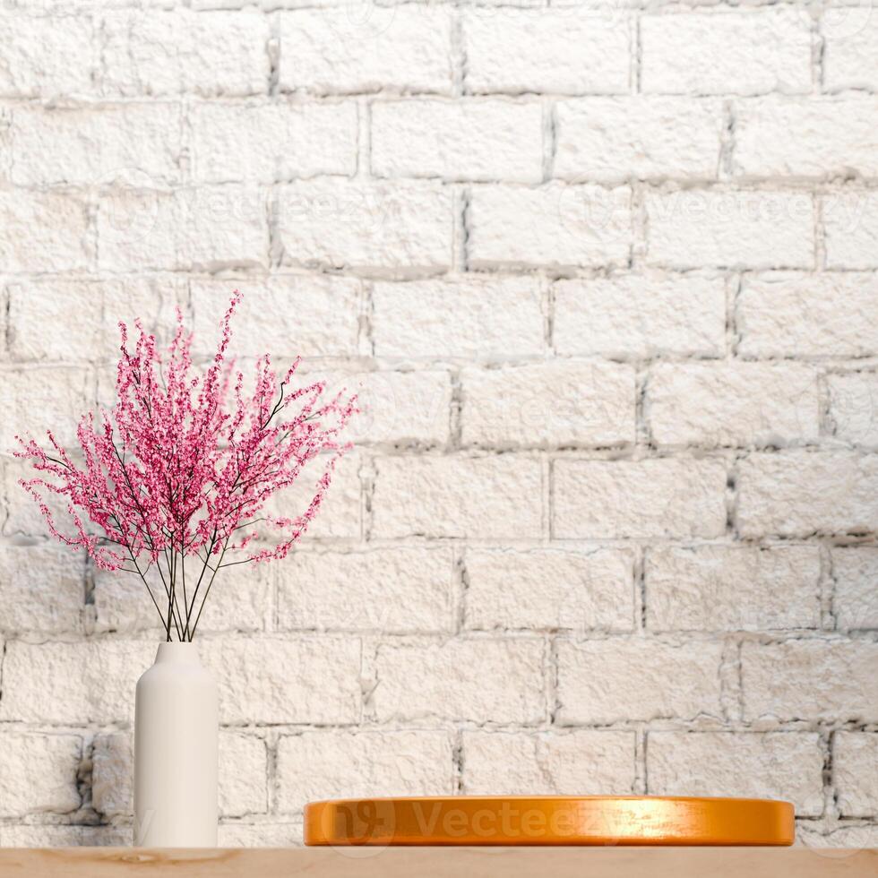 3D A golden platform is shown on a light surface, with a vase of pink flowers to the left. The backdrop is a white brick wall. The scene is minimalist and has a rustic, natural feel. photo