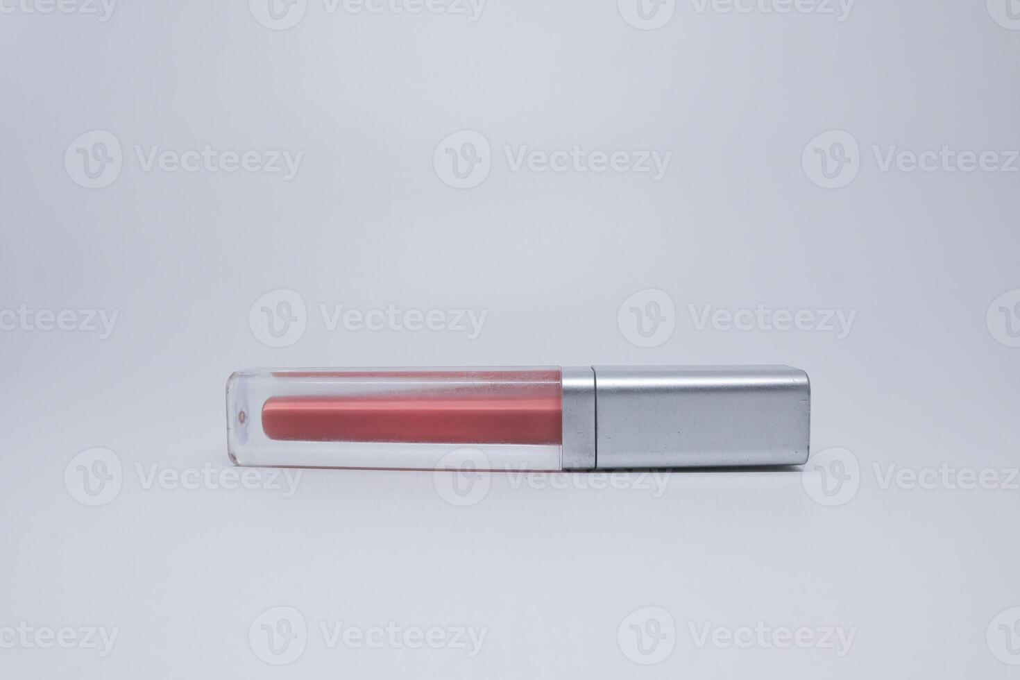 A lipstick with a clear lid on a white surface photo