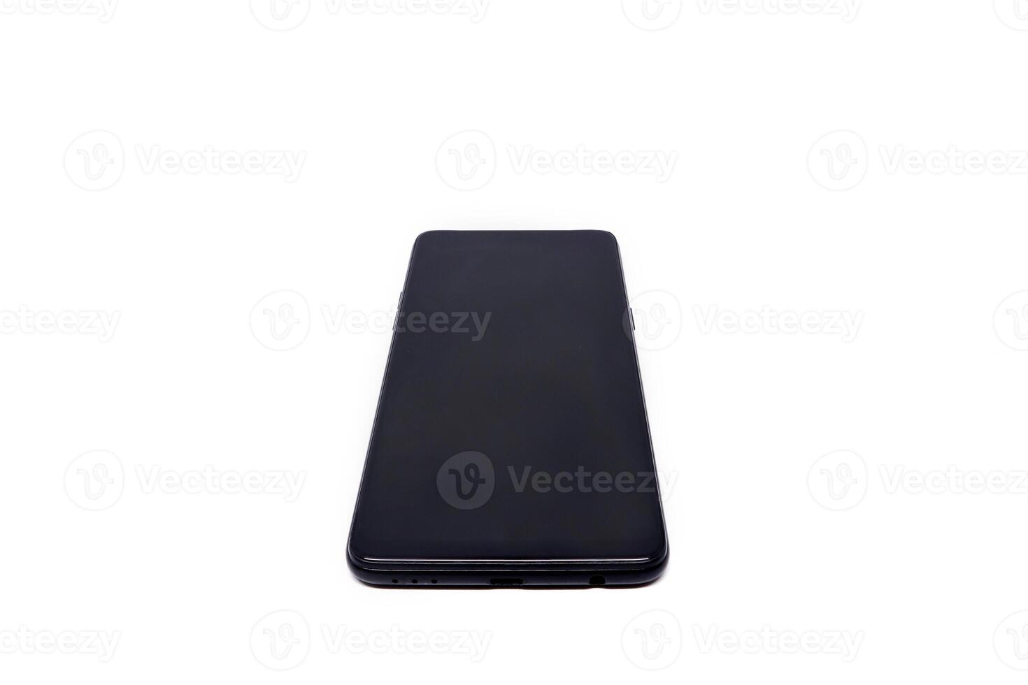 A black smartphone on a white surface photo