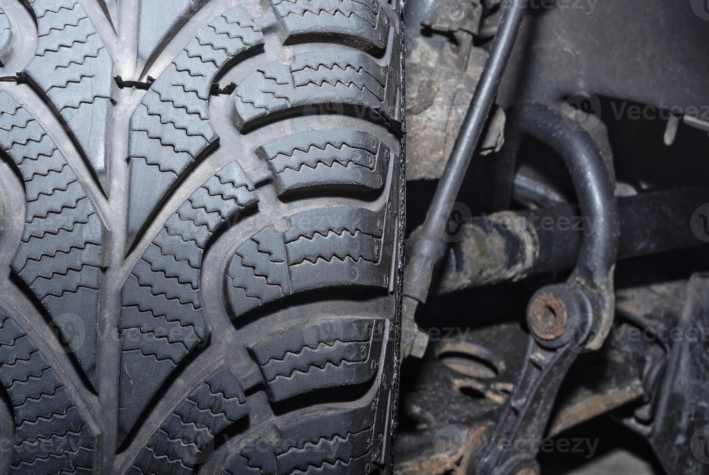 Car wheel tread close up and suspension system elements photo