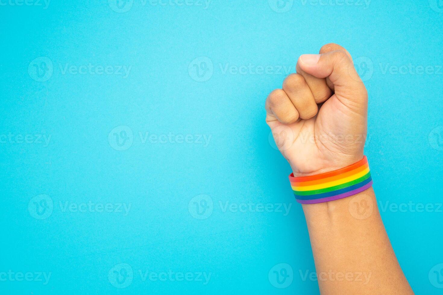 Top view of rainbow wristband in the wrist on a blue background photo