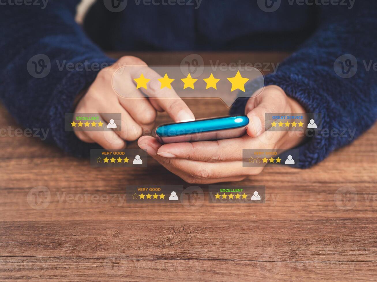 Close-up of hands using a smartphone gives the five-star icon a rating of very impressed for service while sitting at the table photo