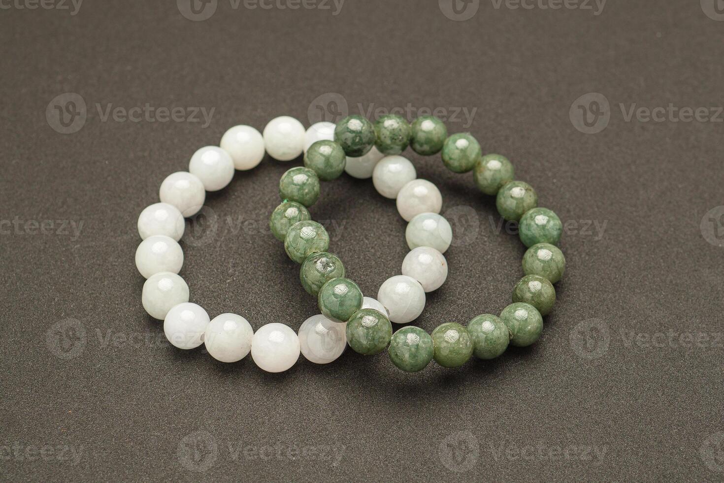 Top view of white and green jade rings on a black background photo