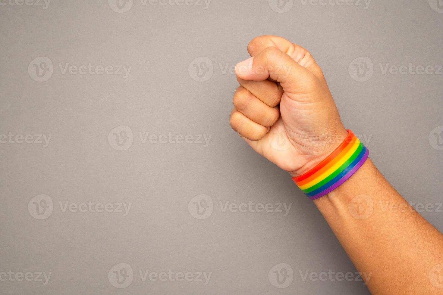 Top view of rainbow wristband in the wrist on a gray background photo