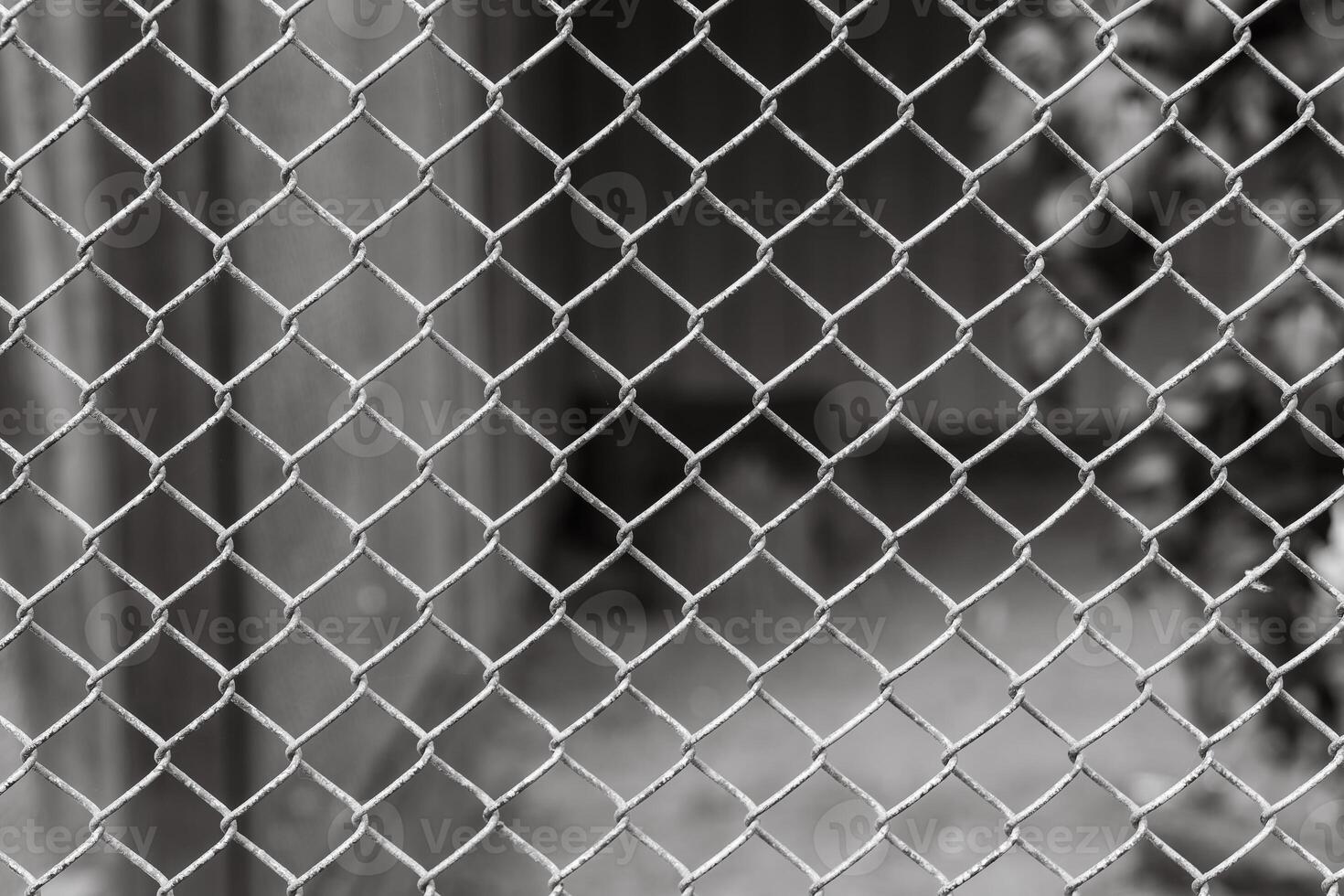 Close-up view of chain link fence with blurred background showcasing an urban environment and a sense of confinement photo