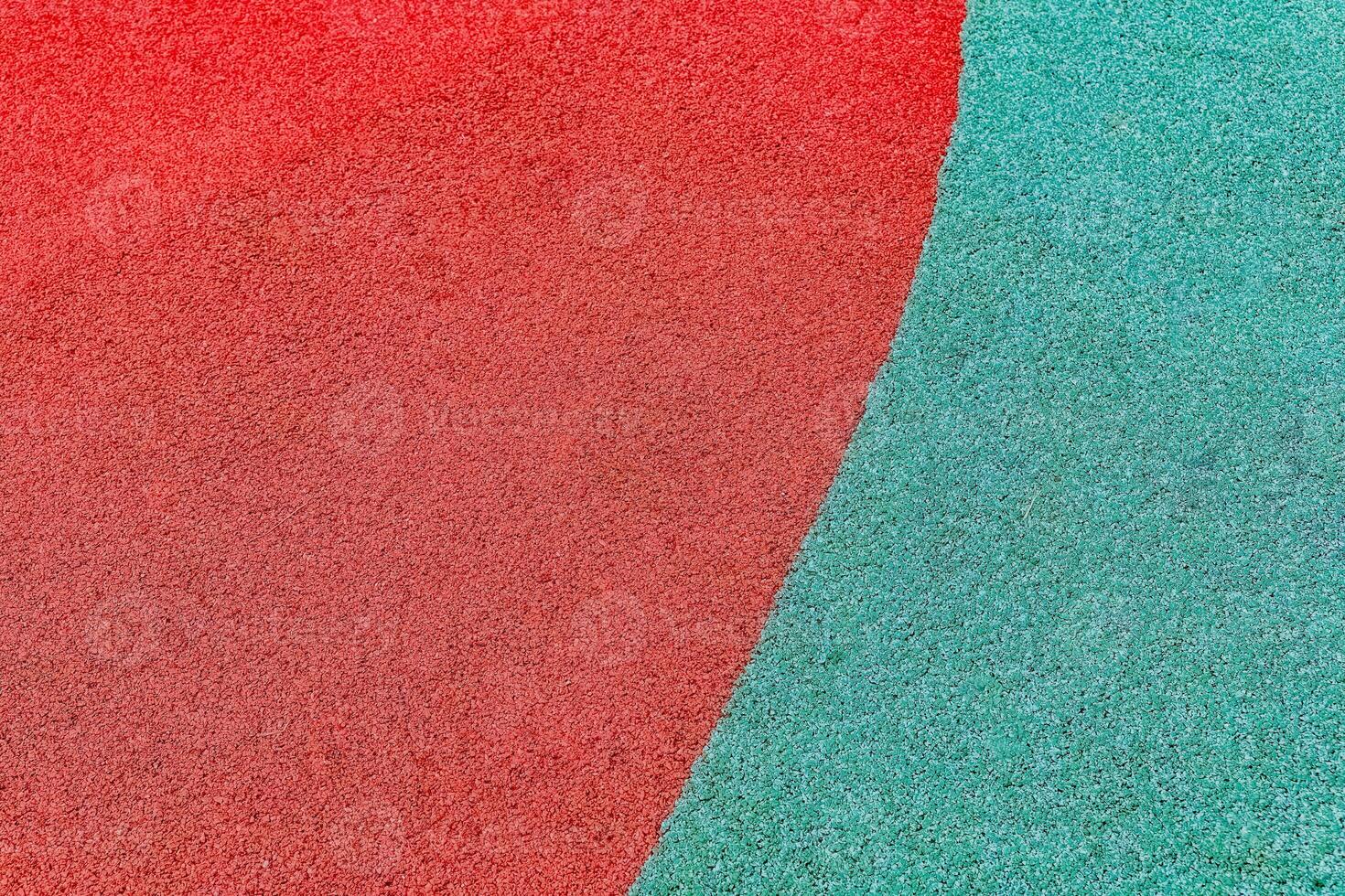 Colorful playground surface showcasing vibrant red and teal rubber materials used for safety and play areas in an outdoor setting photo
