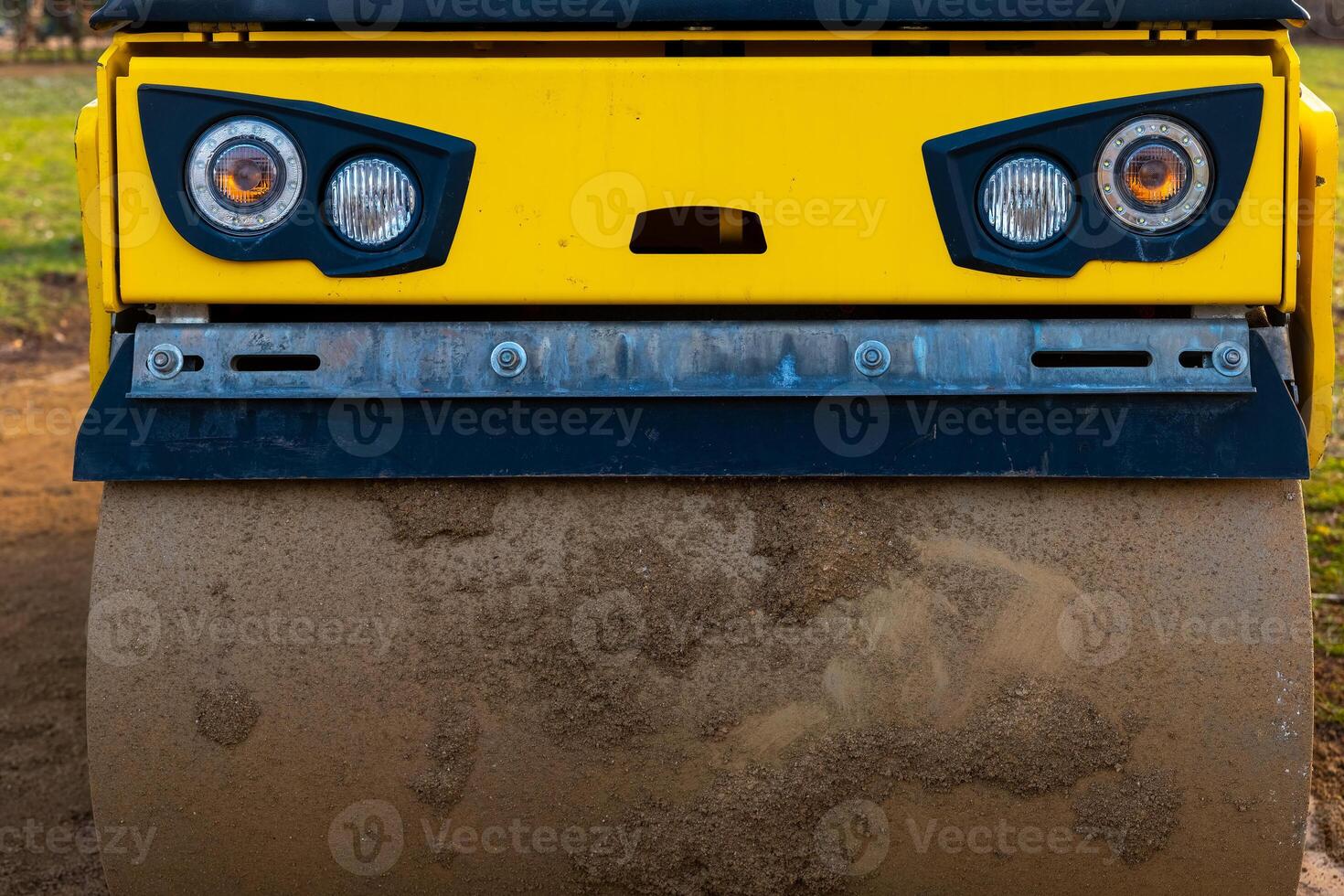 Heavy machinery compactor working on a construction site during daylight photo