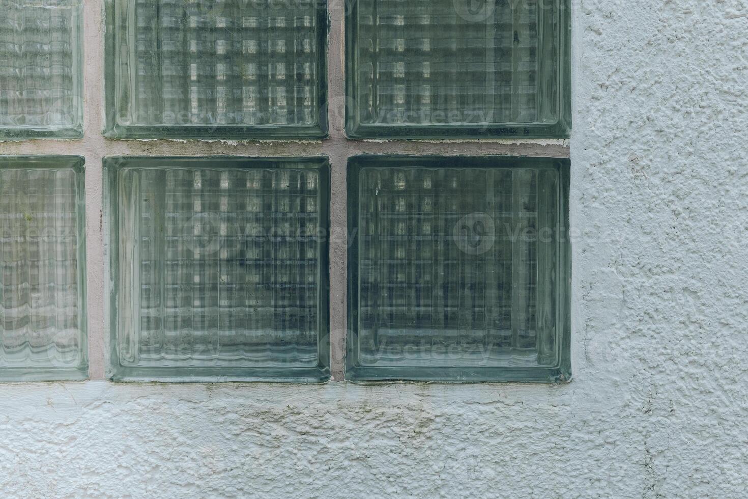 Textured glass blocks set in a white wall showing an interesting play of light and shadow during the day photo