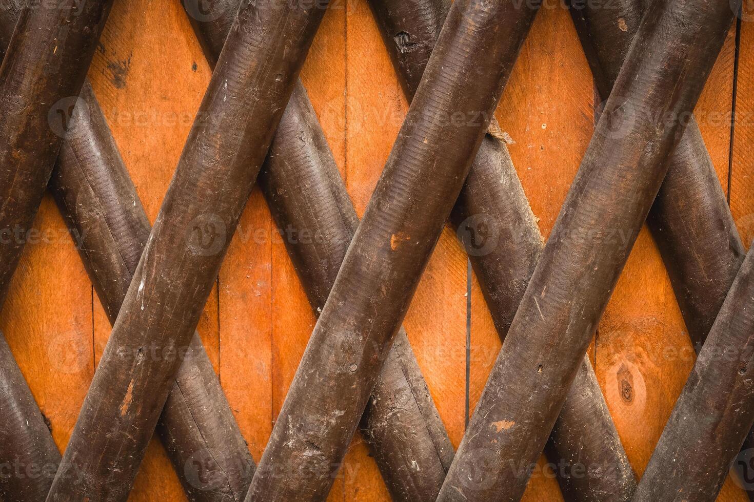 Wooden lattice design with diagonal slats creating a geometric pattern in a rustic setting photo