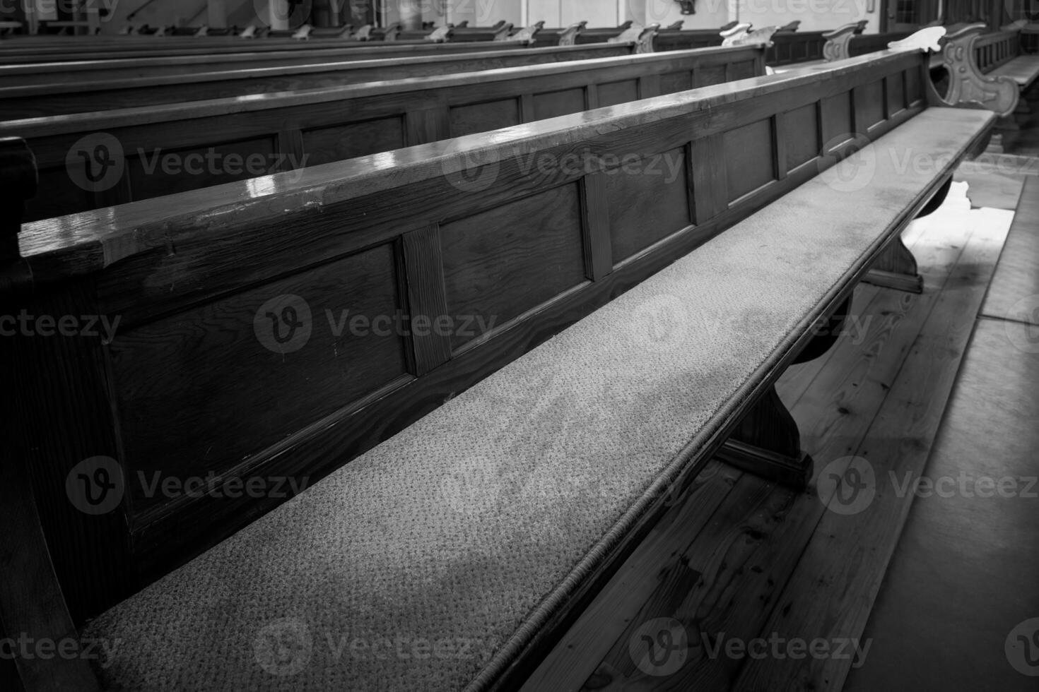 Wooden church benches arranged in rows with soft carpeting in a quiet spiritual setting photo