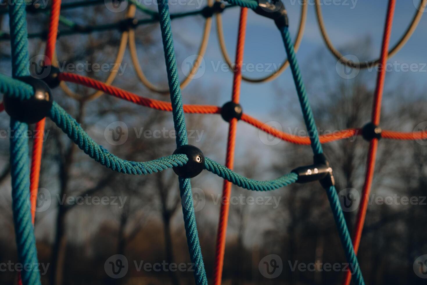 Brightly colored playground climbing structure in a park during a sunny day photo
