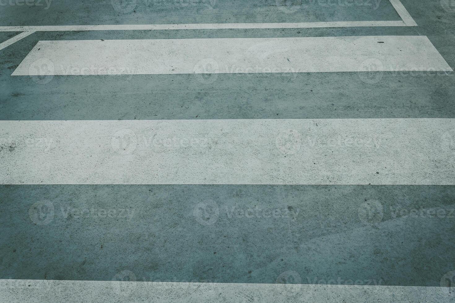 Pedestrian crossing lines on pavement in urban area during daylight hours photo