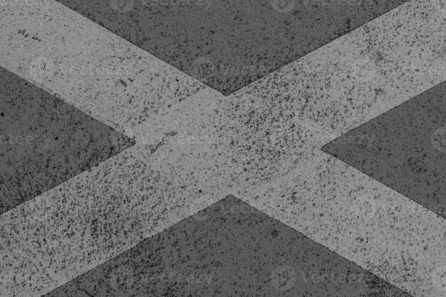 Scotland flag painted on a weathered surface showing signs of wear and age in a street setting during daylight hours photo
