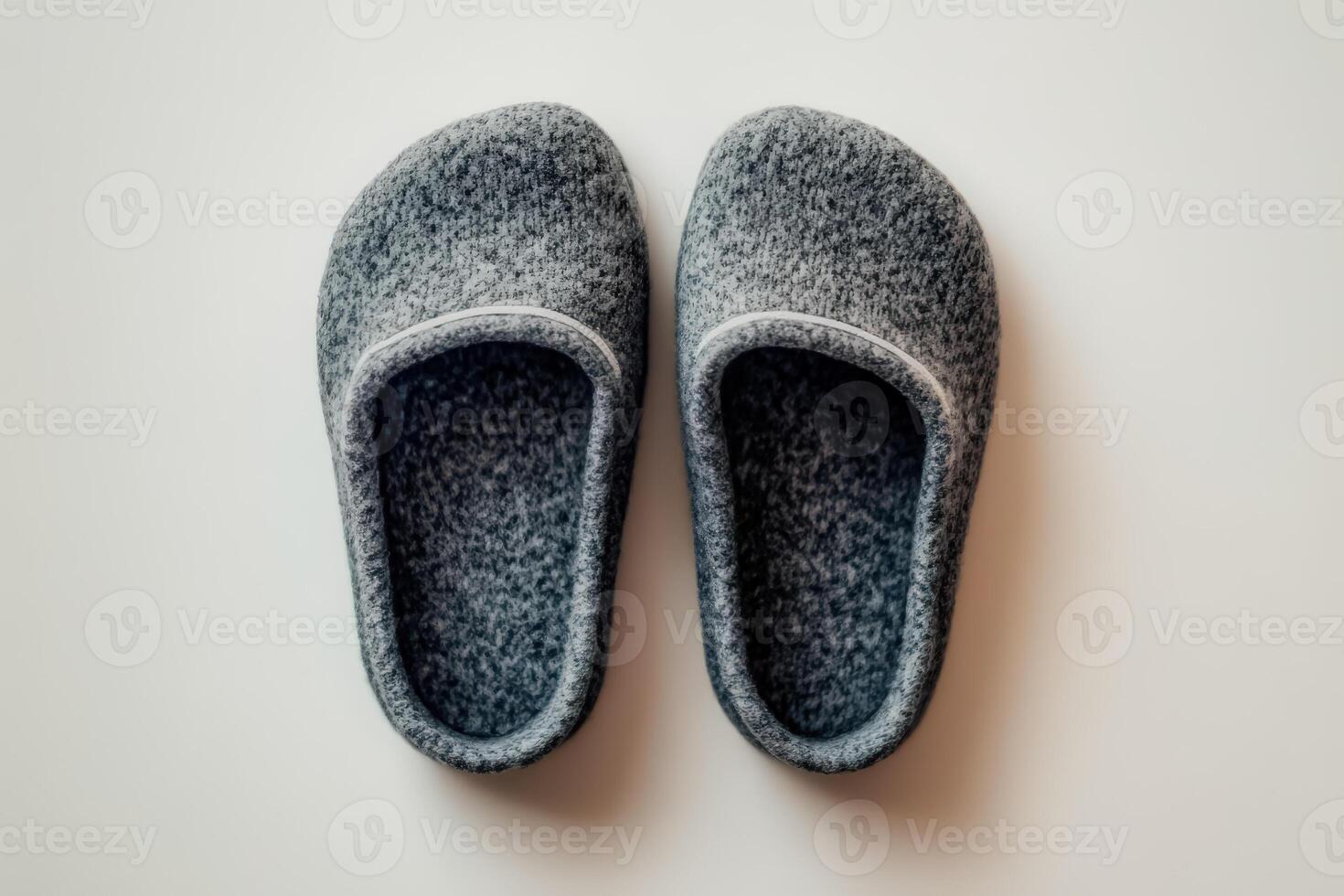 A single pair of gray slippers placed neatly on a white surface photo