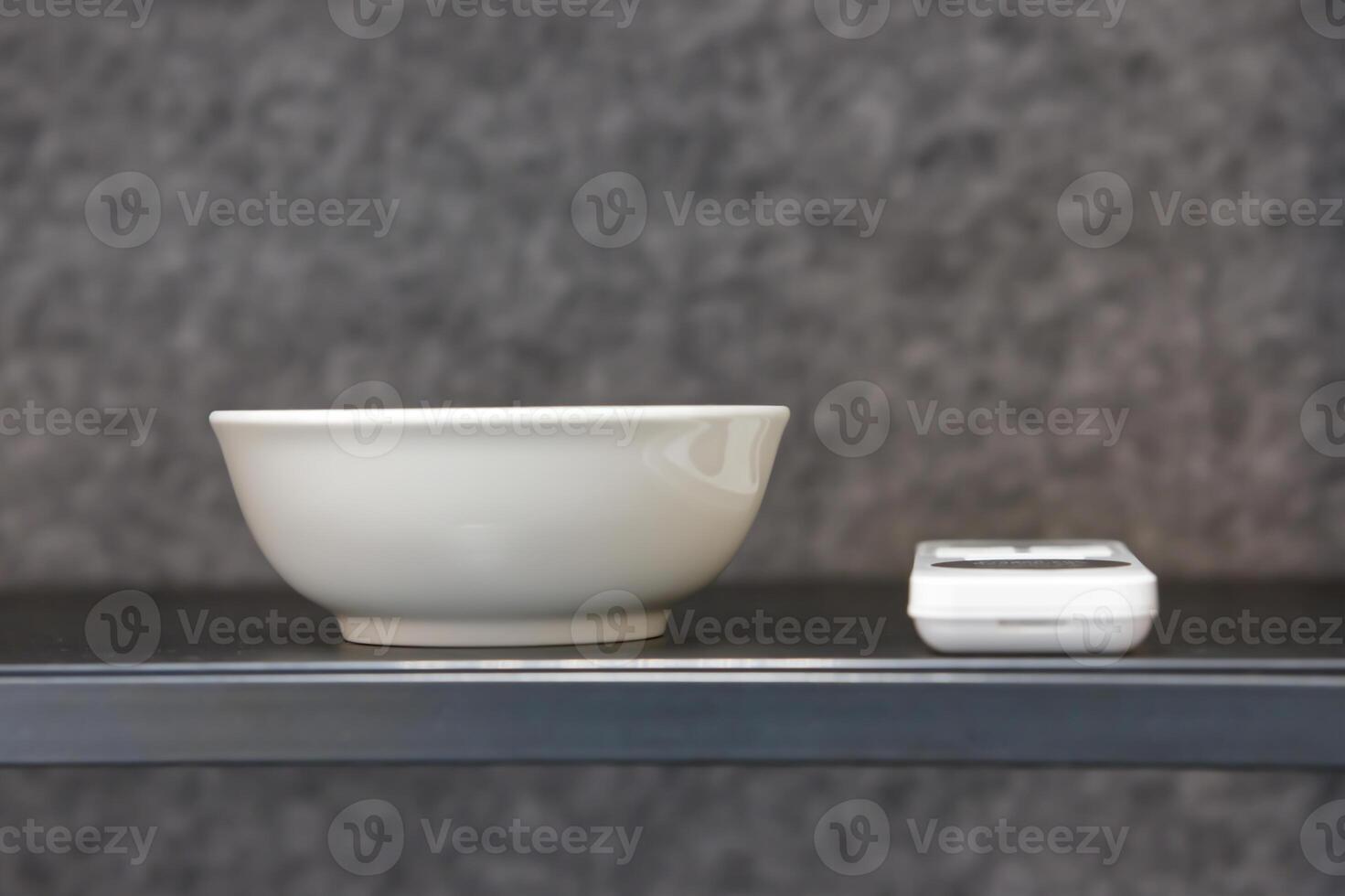 Minimalist White Bowl and Electronic Device on Shelf photo