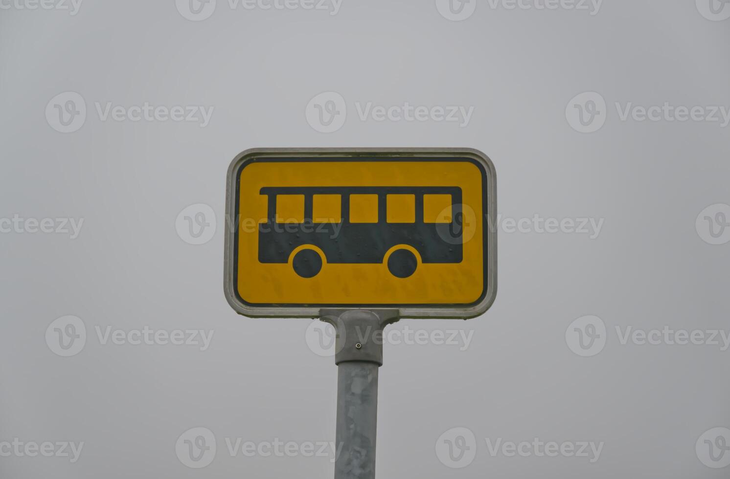 Bus Stop Sign Against Gray Sky photo