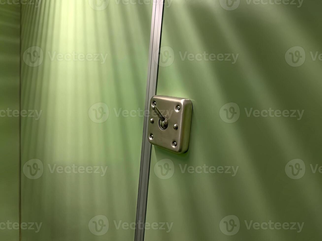 Close-Up of Metallic Latch on Green Wall photo