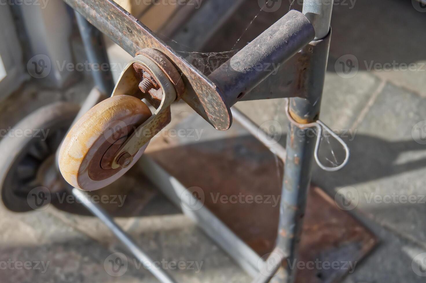 Close-Up of a Rusty Metal Cart with Worn Wheel photo