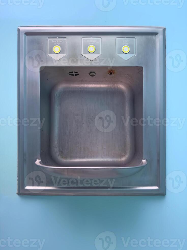 Stainless Steel Sink with Knobs on Blue Background photo