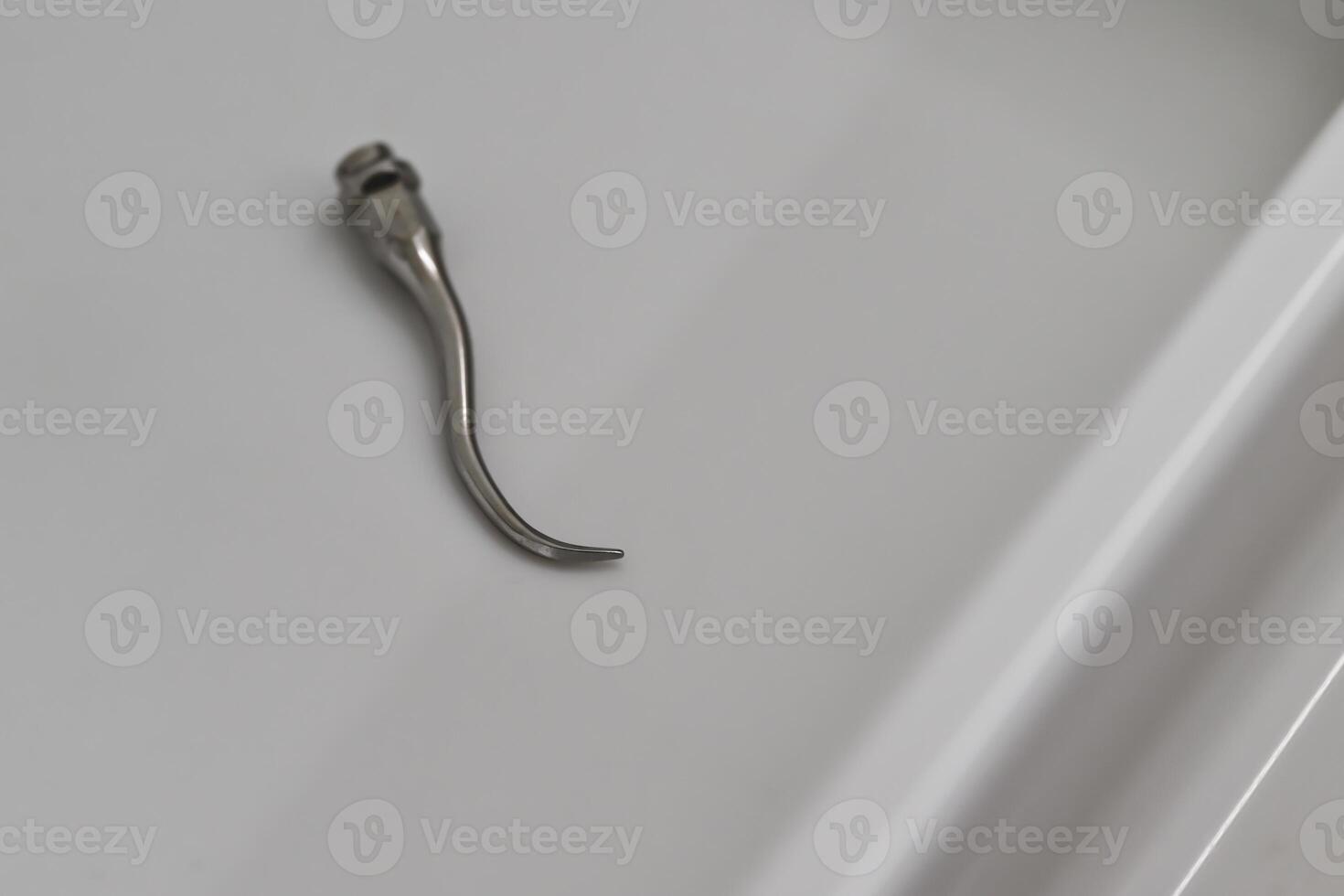 Close-up of a Metallic Hook Tool on a Smooth Surface photo