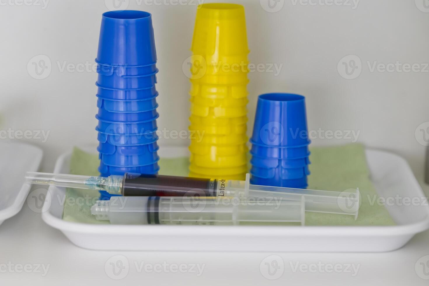 Medical Syringes and Colorful Cups on Tray photo