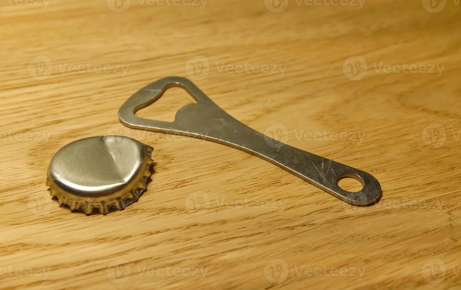 Bottle Opener and Cap on Wooden Surface photo