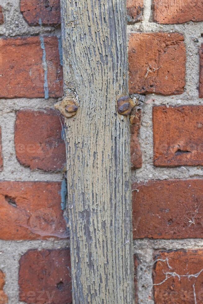 Wooden Post Against Brick Wall photo
