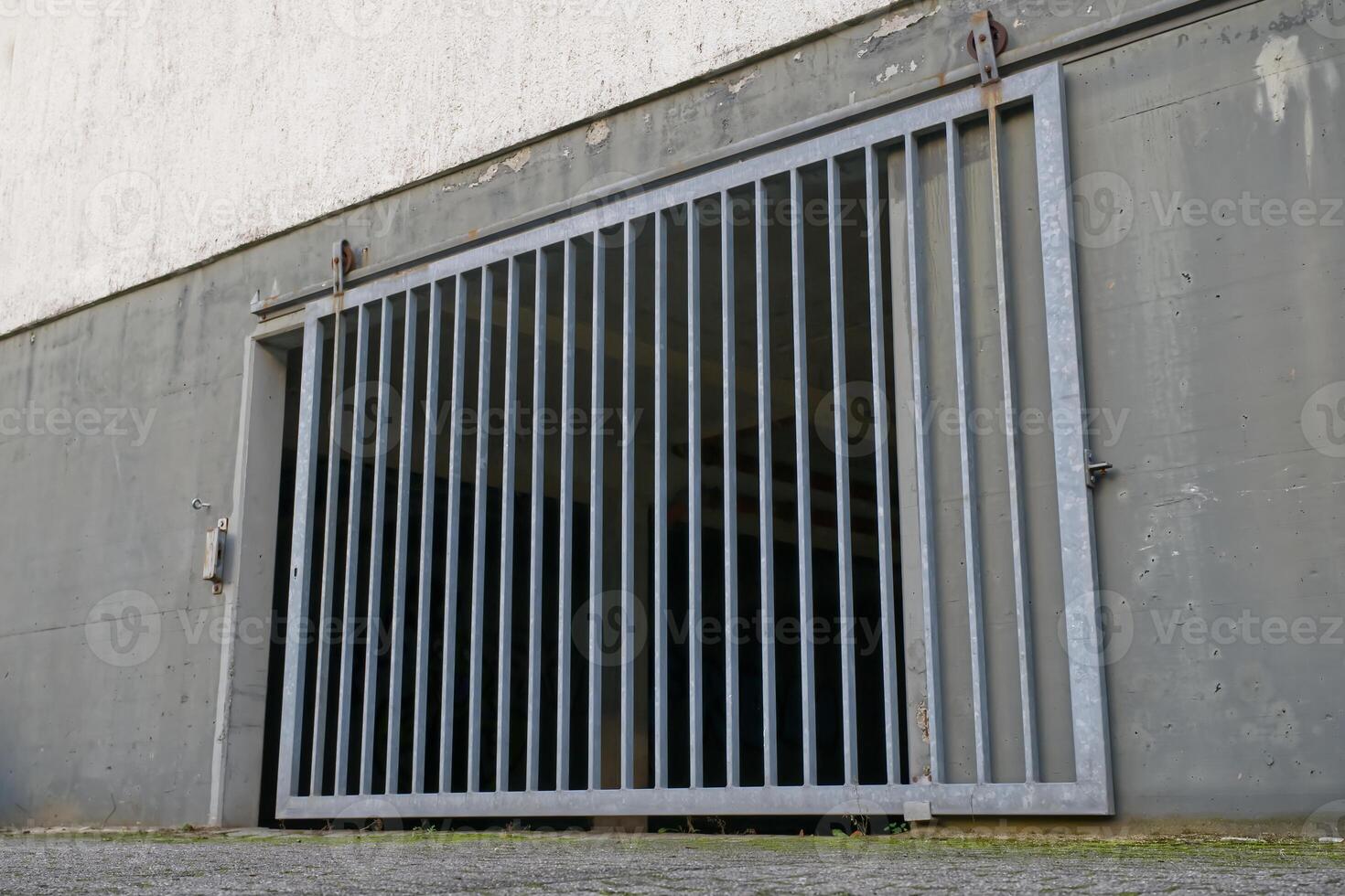 Metal Barred Gate Against Concrete Wall photo