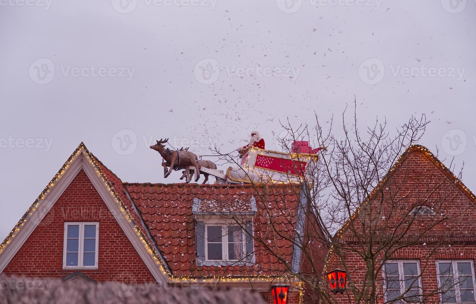 Santa Claus on Rooftop with Reindeer in Snow photo