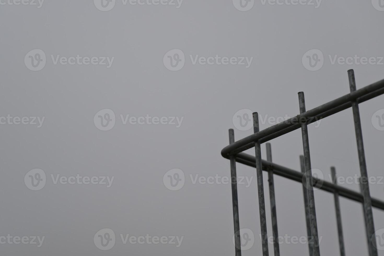 Minimalist Metal Fence Against Gray Sky photo