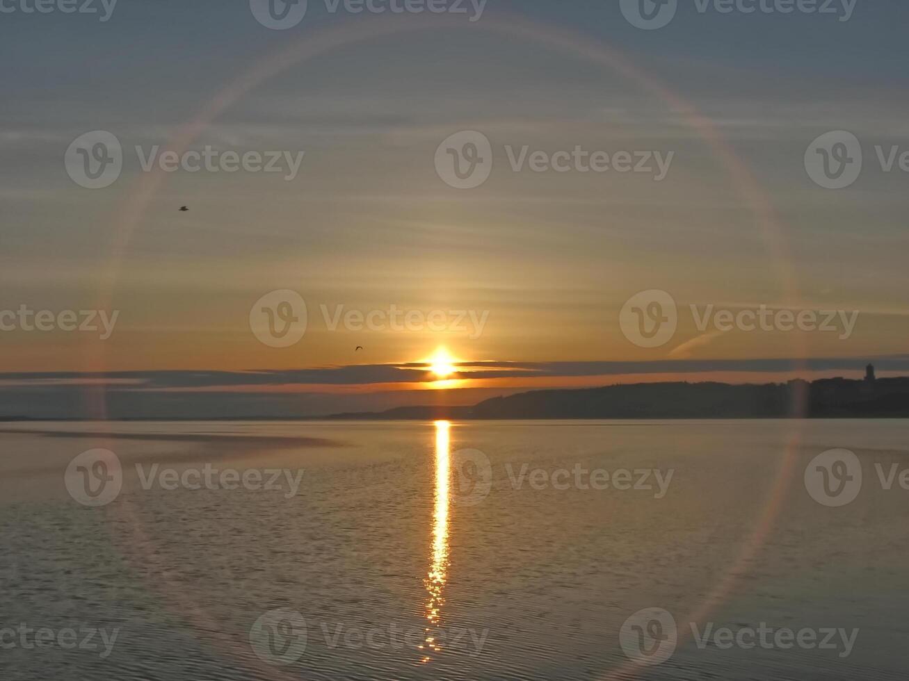 Tranquil Sunset with rare solar corona Over Water photo