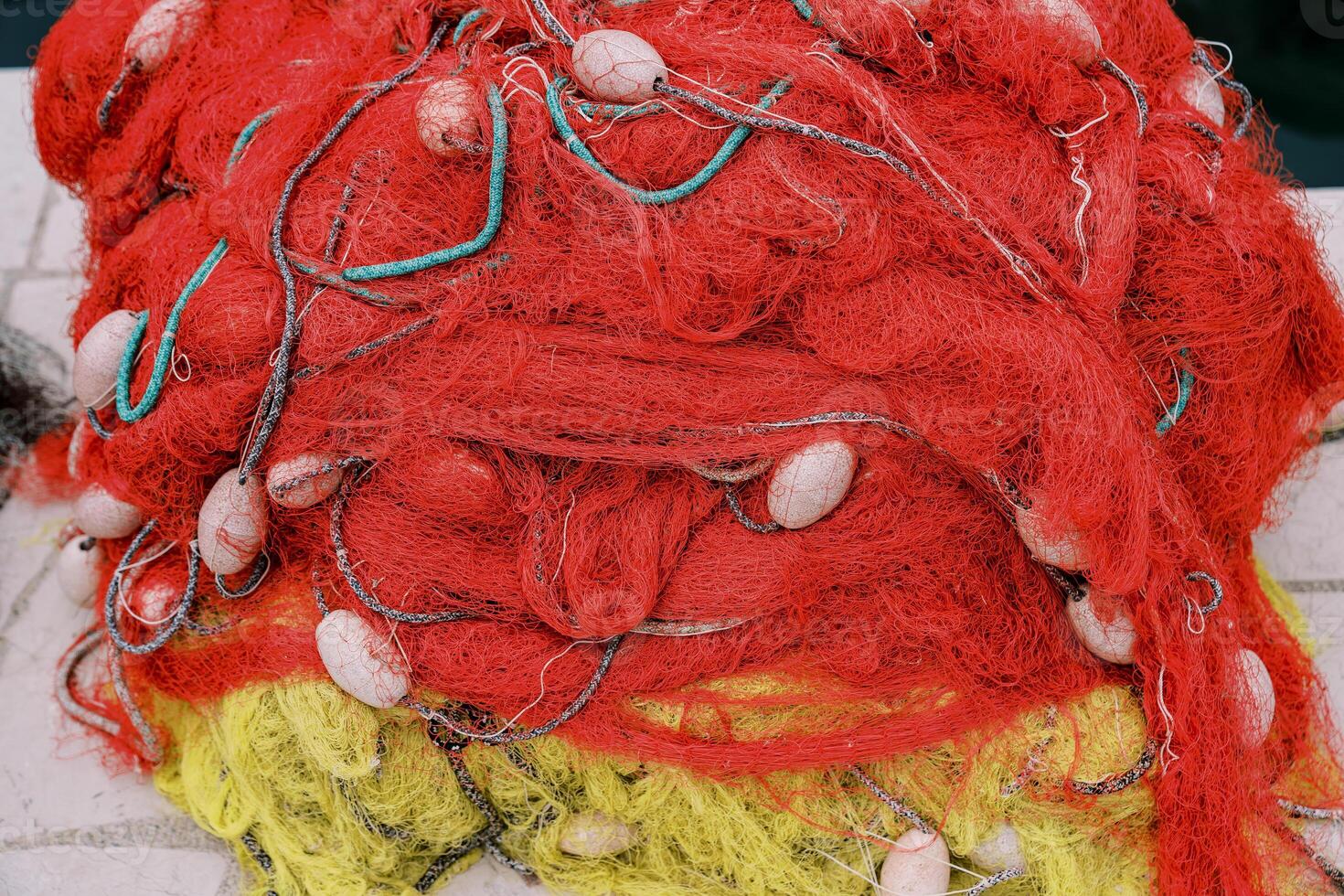 Red and yellow fishing net lies on the pier. Top view photo