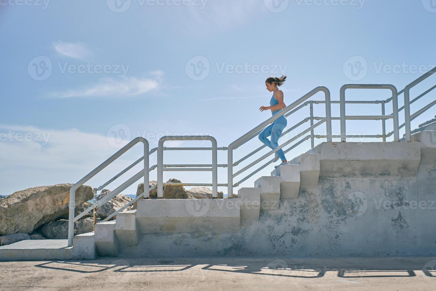 Runner jogging on staircase during workout in sunlight photo