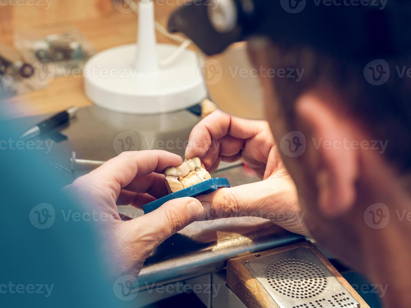 Crop orthodontist technician making jaws casts in laboratory photo