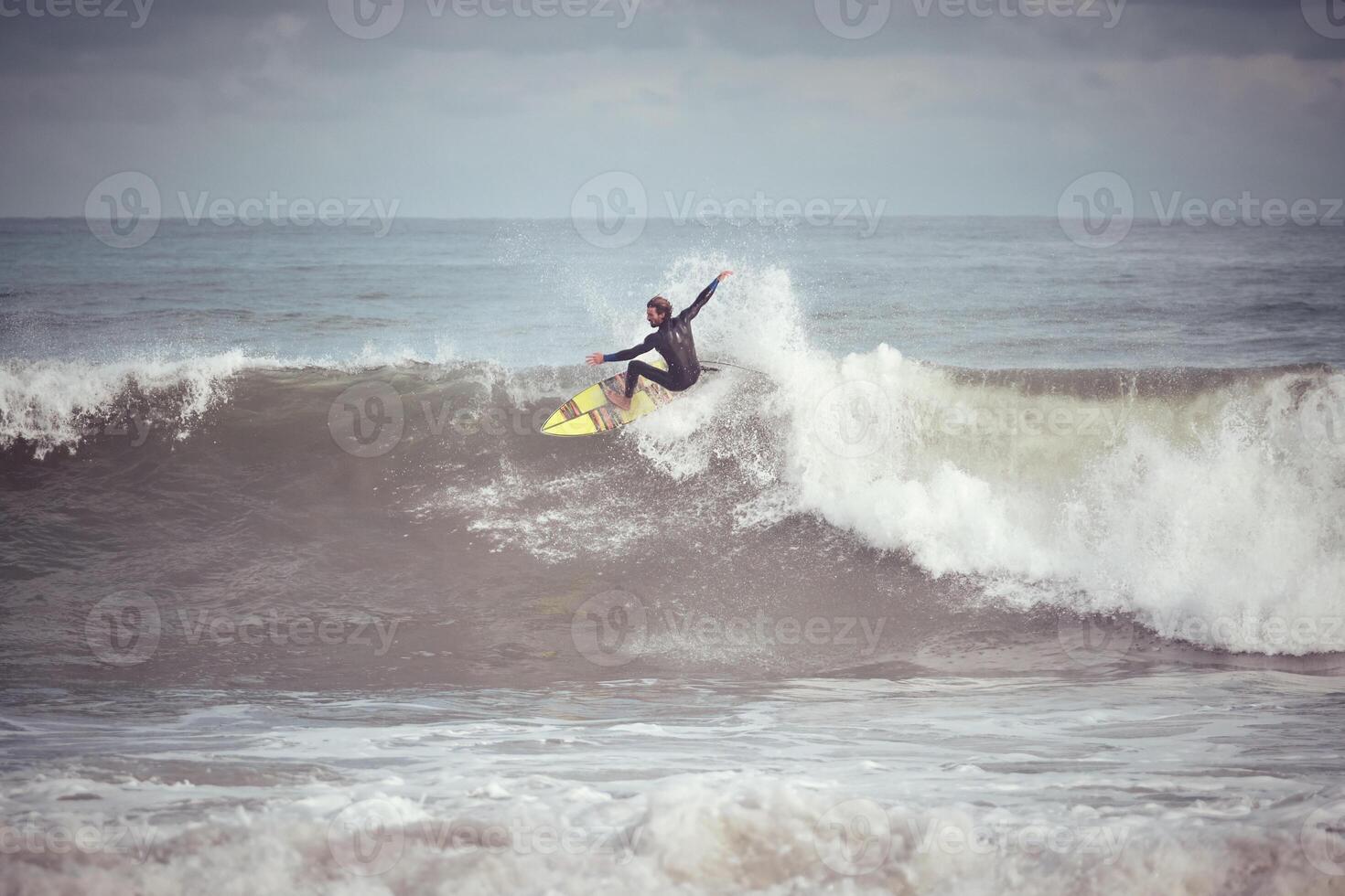 Man surfer on surfboard catching wave on ocean photo