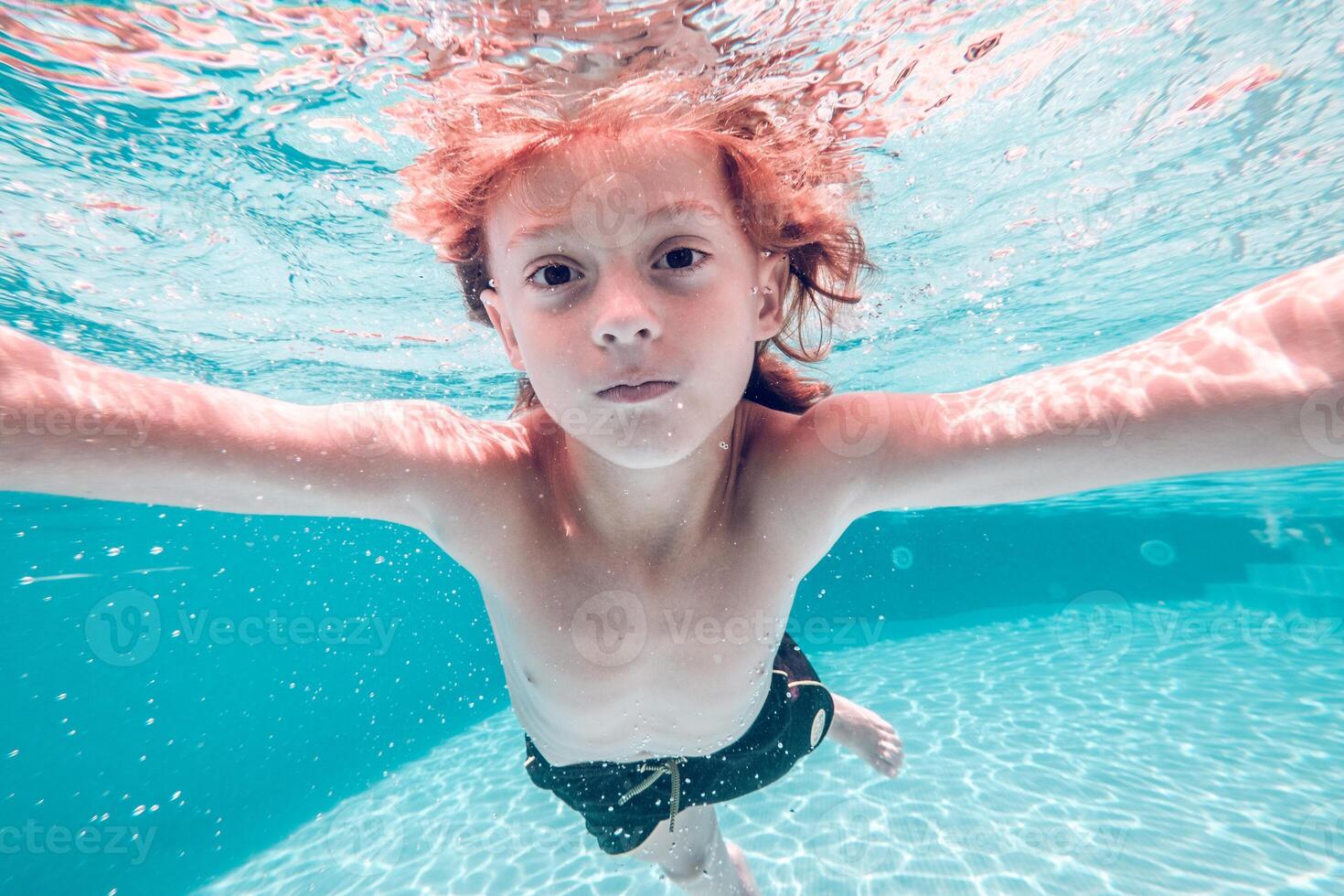 Little boy swimming in clean pool water photo