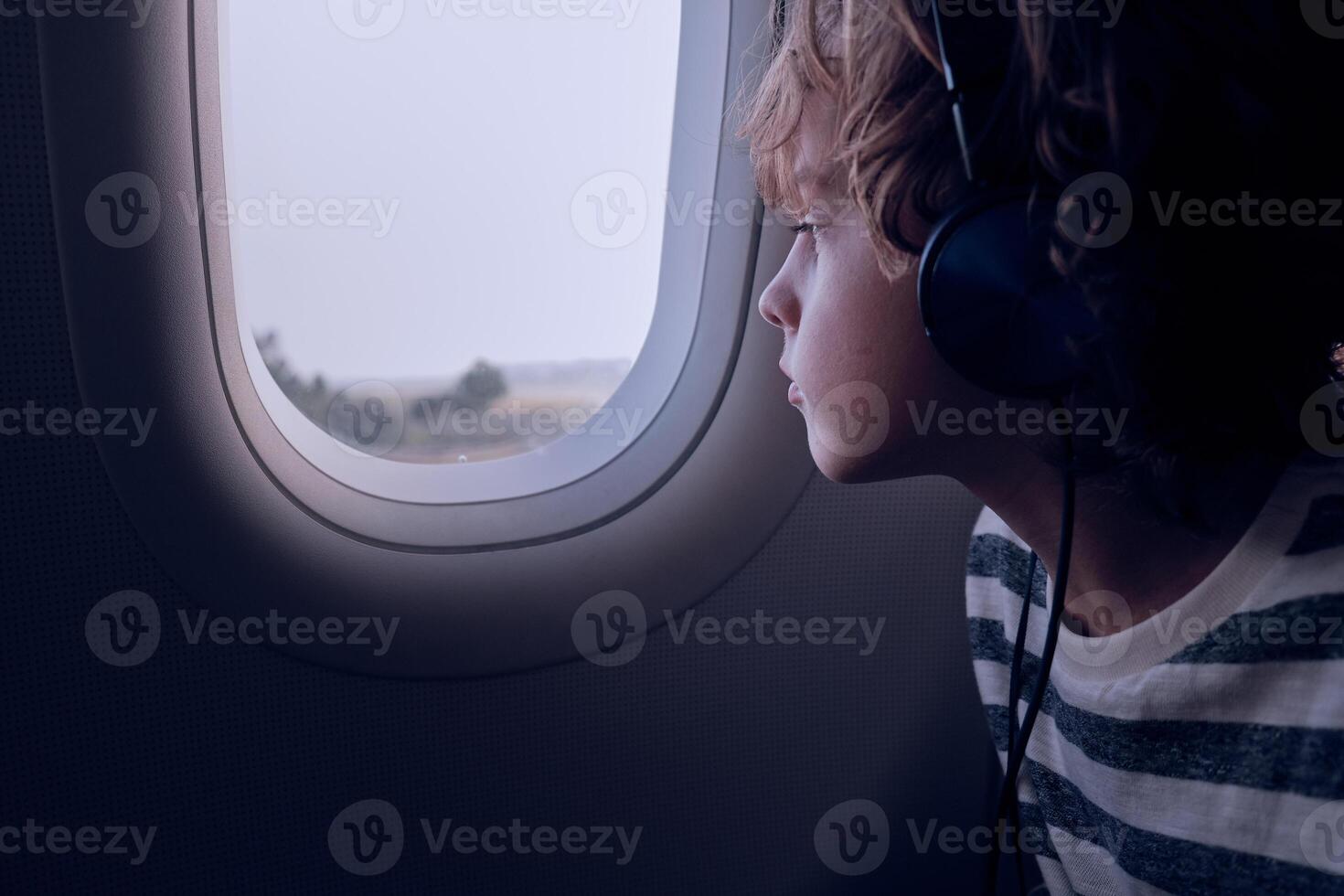Boy looking out plane window photo
