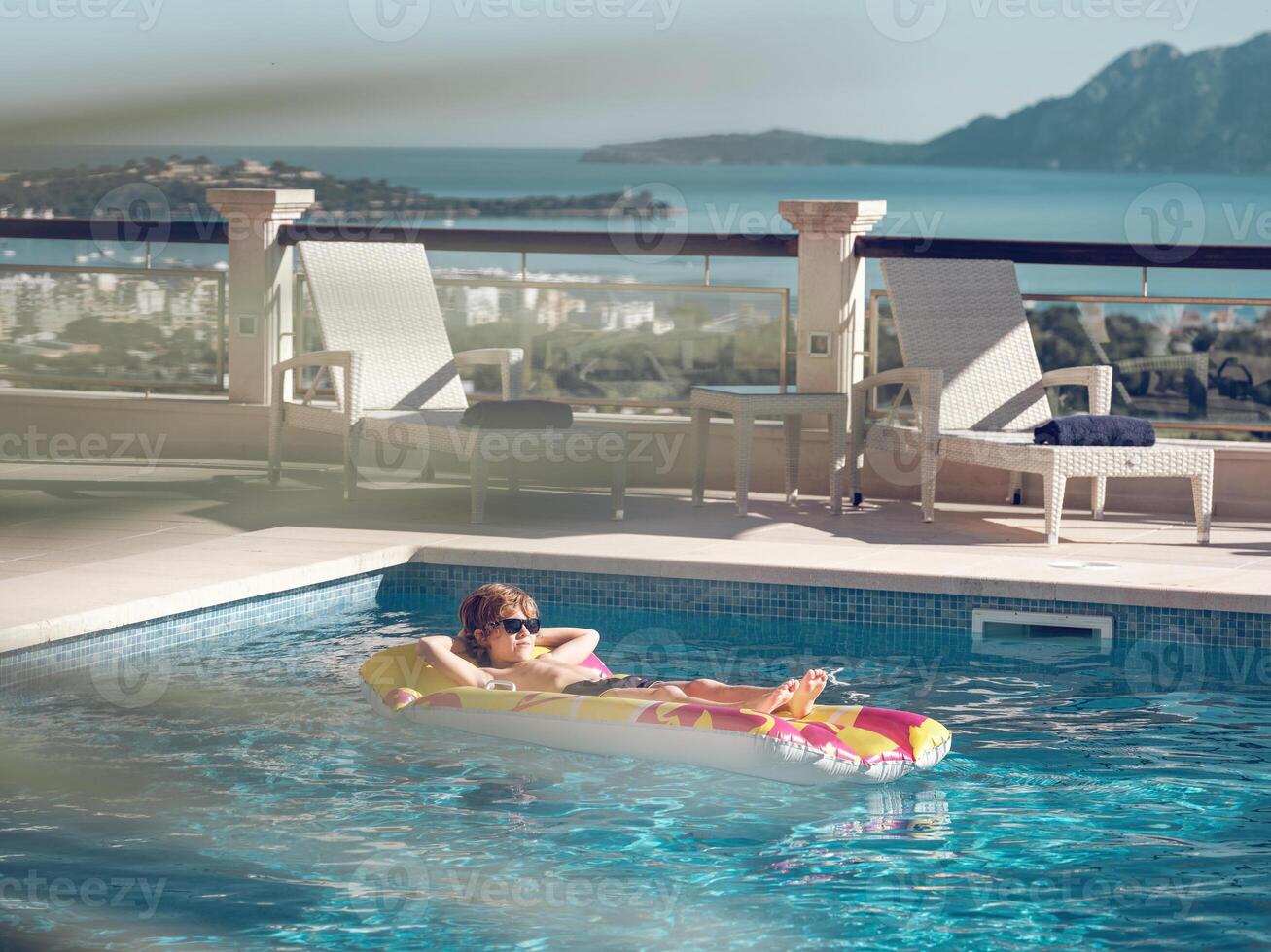Boy resting in hotel swimming pool photo